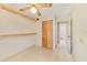 Bedroom with neutral tones and tile floor, wood closet door, and shelf storage at 7024 Harwick Dr, Orlando, FL 32818