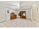 Spacious living area with white tile, ceiling fan, and retro wood shelving with mirrored backdrop at 7024 Harwick Dr, Orlando, FL 32818