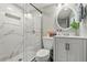 Modern bathroom featuring marble tile in shower, glass door, and sleek white vanity at 704 Honeysuckle Ave, Kissimmee, FL 34747