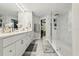 Bathroom with large vanity, double sinks, and white tile shower with glass door at 704 Honeysuckle Ave, Kissimmee, FL 34747
