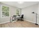 Bedroom with hardwood floors, large windows, computer desk, and natural light at 704 Honeysuckle Ave, Kissimmee, FL 34747