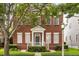 Charming two-story brick home with a well-manicured lawn and lovely green door at 704 Honeysuckle Ave, Kissimmee, FL 34747