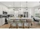 Bright kitchen with white cabinets, stainless steel appliances, pendant lighting, and a large island with seating at 704 Honeysuckle Ave, Kissimmee, FL 34747
