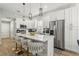 Modern kitchen features white cabinets, stainless steel appliances, a center island with seating, and modern lighting at 704 Honeysuckle Ave, Kissimmee, FL 34747