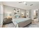 A bright main bedroom with neutral walls, stylish decor and an open en-suite bathroom at 704 Honeysuckle Ave, Kissimmee, FL 34747