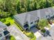 Aerial view of a multi-story townhome featuring lush landscaping, blue shutters, and a paver driveway at 707 Evening Sky Dr, Oviedo, FL 32765