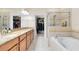Spacious bathroom with granite counters, double sinks, a soaking tub, and glass enclosed shower at 707 Evening Sky Dr, Oviedo, FL 32765