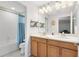 Bathroom featuring a double vanity, large mirror, and a bathtub with shower and blue curtain at 707 Evening Sky Dr, Oviedo, FL 32765