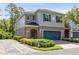 Charming two-story townhome featuring a blue garage door, blue shutters, and well-manicured landscaping at 707 Evening Sky Dr, Oviedo, FL 32765