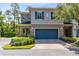 Two-story townhome featuring a brick driveway, a blue garage door, manicured landscaping, and decorative outdoor lighting at 707 Evening Sky Dr, Oviedo, FL 32765