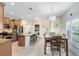 Open kitchen with stainless appliances, granite island with barstool seating, and adjacent dining area at 707 Evening Sky Dr, Oviedo, FL 32765