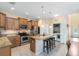 Open kitchen with island, stainless steel appliances, granite countertops, and view to the laundry room at 707 Evening Sky Dr, Oviedo, FL 32765