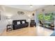 Living room has wood flooring, a ceiling fan, and a sliding glass door opening to the outdoor patio with nature views at 707 Evening Sky Dr, Oviedo, FL 32765