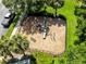 Overhead view of a fenced playground with a swing set, slide, and other playground equipment and mature landscaping at 707 Evening Sky Dr, Oviedo, FL 32765