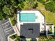 Aerial view of community pool with parking, bathrooms and lounging area surrounded by lush greenery and landscaping at 707 Evening Sky Dr, Oviedo, FL 32765