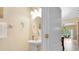 Clean half bathroom with a pedestal sink, round mirror, and natural lighting at 707 Evening Sky Dr, Oviedo, FL 32765