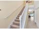 Bright foyer showcasing a carpeted staircase with white railing and view into the adjacent living area at 707 Evening Sky Dr, Oviedo, FL 32765
