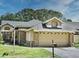 Charming single-story home featuring an attached two-car garage with a well maintained lawn and mature trees at 724 Barrington Cir, Winter Springs, FL 32708