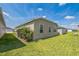 Backyard featuring a well-maintained lawn and the exterior of the home with multiple windows at 747 Louise Ln, The Villages, FL 32163