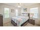 Bright bedroom featuring double windows, a nightstand, and beach artwork at 747 Louise Ln, The Villages, FL 32163