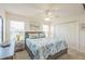 Bright bedroom featuring nautical-themed bedding, ceiling fan, and double windows at 747 Louise Ln, The Villages, FL 32163