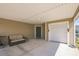 Cozy covered carport featuring a grill and comfortable seating, leading to the garage and front door at 747 Louise Ln, The Villages, FL 32163