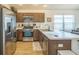 Kitchen featuring stainless steel appliances, brown cabinets, and a functional layout with view into dining area at 747 Louise Ln, The Villages, FL 32163