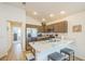 Bright kitchen featuring brown cabinets, stainless steel appliances, and an island with seating for casual dining at 747 Louise Ln, The Villages, FL 32163