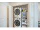 Convenient laundry room featuring stacked washer and dryer, shelving for storage, and easy access at 747 Louise Ln, The Villages, FL 32163