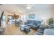 Open-concept living room featuring a comfortable gray sofa set, a dining area, and a modern kitchen at 747 Louise Ln, The Villages, FL 32163