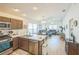 Bright living room with wood floors, stainless steel appliances, open concept kitchen, and comfortable seating arrangement at 747 Louise Ln, The Villages, FL 32163
