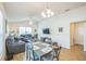 Open-concept living and dining area with comfortable seating, dining table, and wood flooring, bathed in natural light at 747 Louise Ln, The Villages, FL 32163