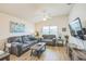 Bright and airy living room with plush gray sofas, a stylish coffee table, and a view of the adjacent dining area at 747 Louise Ln, The Villages, FL 32163