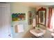 Inviting bathroom featuring white fixtures, mirror, towel rack, and colorful wall art at 748 W Florence Ave, Deland, FL 32720