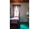 Cozy bedroom featuring a single bed, wainscoted walls, and window with curtains at 748 W Florence Ave, Deland, FL 32720