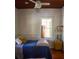 Simple bedroom featuring a wood-paneled wall, bright window, and hardwood floors at 748 W Florence Ave, Deland, FL 32720