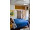 Comfortable bedroom with overhead storage, bright blue bedding, and adjacent doorway at 748 W Florence Ave, Deland, FL 32720
