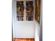 Narrow hallway with hardwood floors, beadboard paneling, and built-in bookshelves at 748 W Florence Ave, Deland, FL 32720