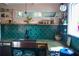 A farmhouse kitchen featuring a stainless steel sink and countertops and green backsplash tiles at 748 W Florence Ave, Deland, FL 32720
