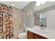 Bathroom featuring vanity, shower with tub, and an orange-themed shower curtain at 8445 Leeland Archer Blvd, Orlando, FL 32836