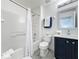 A bathroom featuring a tub and shower with white tiles, a toilet, and a vanity with navy cabinetry at 8518 La Isla Dr, Kissimmee, FL 34747