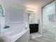 The bathroom has a soaking tub, a dark vanity, neutral paint, and a mirror with decorative sconces at 8518 La Isla Dr, Kissimmee, FL 34747