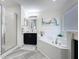 The bathroom is equipped with a tiled-in tub with shower, a vanity with dark wood cabinetry, and neutral paint at 8518 La Isla Dr, Kissimmee, FL 34747