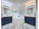 Bathroom featuring dual vanities with a shared tiled-in tub and shower; the room is decorated in neutral colors at 8518 La Isla Dr, Kissimmee, FL 34747
