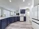 Modern kitchen boasts navy cabinets, stone countertops, and stainless steel appliances at 8518 La Isla Dr, Kissimmee, FL 34747