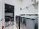 Updated laundry room with modern washer/dryer units and checkerboard floors at 8518 La Isla Dr, Kissimmee, FL 34747