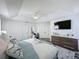 Bright primary bedroom with plank flooring, a ceiling fan, tv and a ensuite bath access at 8518 La Isla Dr, Kissimmee, FL 34747