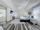 Vaulted ceiling bedroom featuring luxury vinyl plank flooring, tv, ensuite bath and large windows at 8518 La Isla Dr, Kissimmee, FL 34747