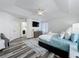 Bright Primary bedroom featuring gray plank flooring, tv, ceiling fan and ensuite bath access at 8518 La Isla Dr, Kissimmee, FL 34747