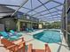 A screened-in pool area with seating, lounge chairs, and covered patio; it's perfect for outdoor entertainment at 8518 La Isla Dr, Kissimmee, FL 34747